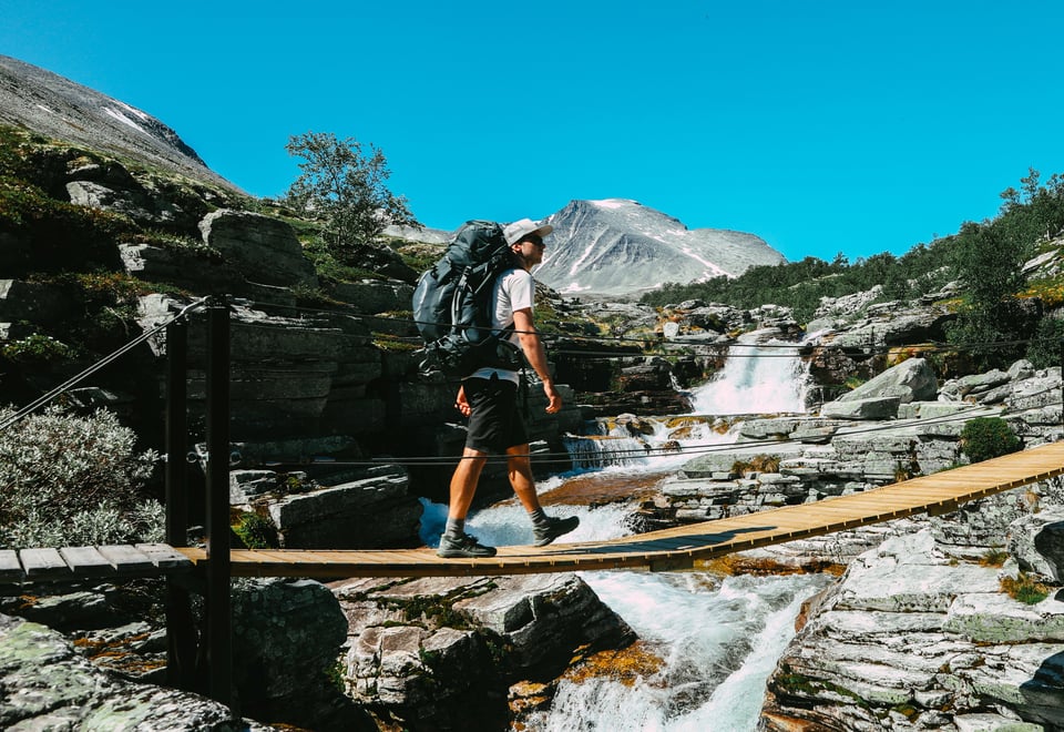 Mann som går over en hengebru