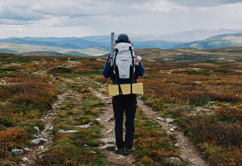 Mann med sekk i høstlandskap