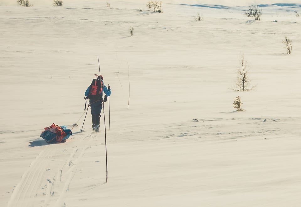 En person som går på ski med pulk i vinterfjellet