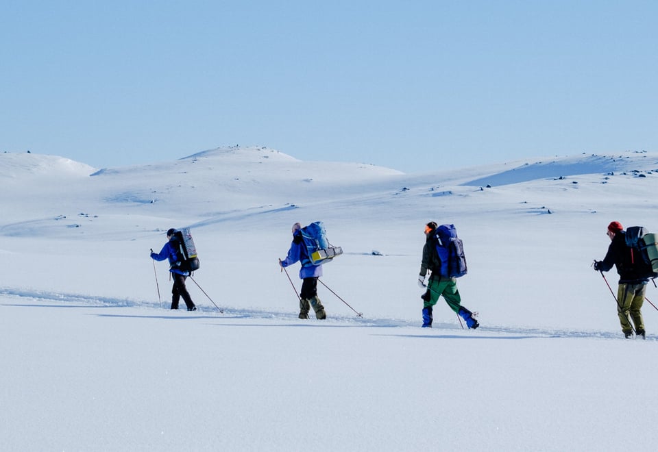 4 personer som går på fjellski i fjellet