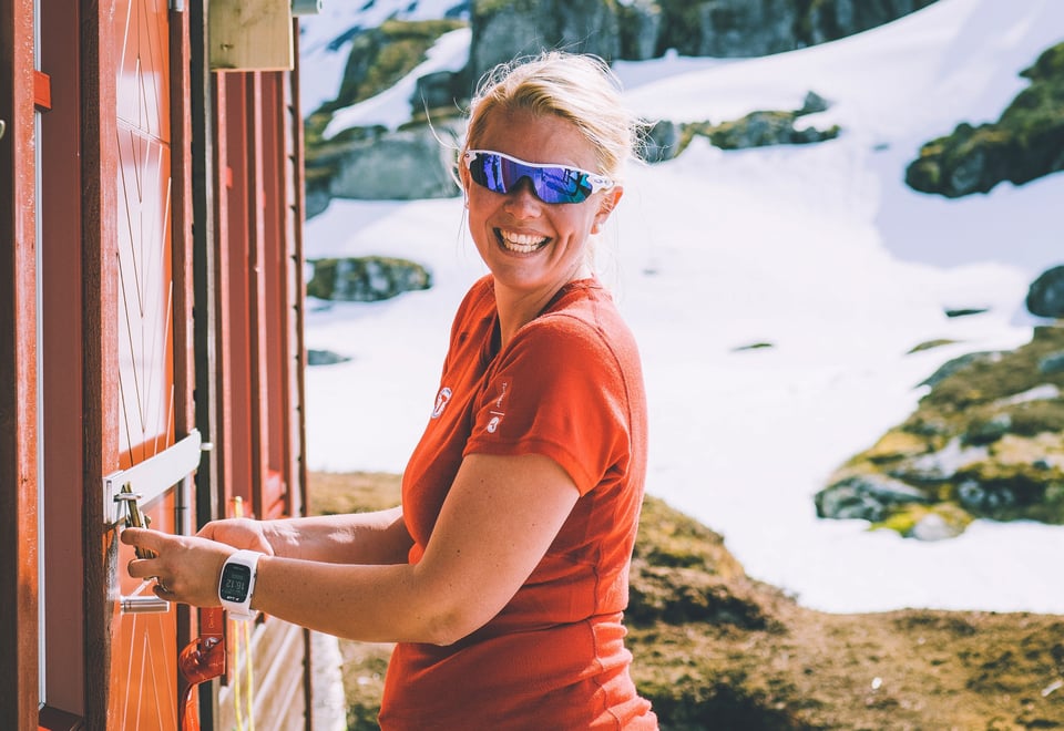 Woman unlocking a DNT-cabin with the DNT-key