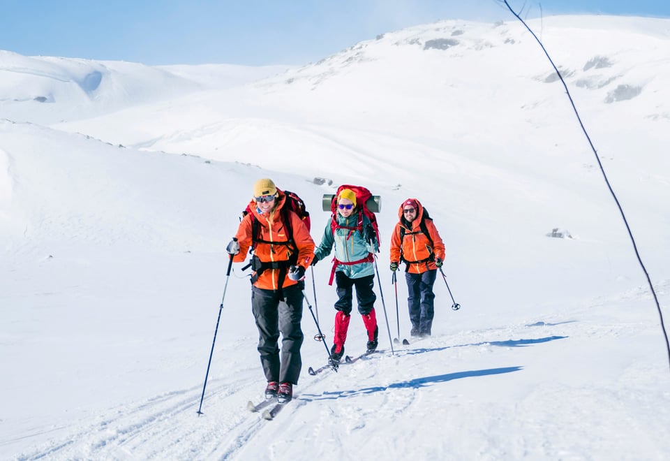 Tre personer som går på fjellski innover vidda