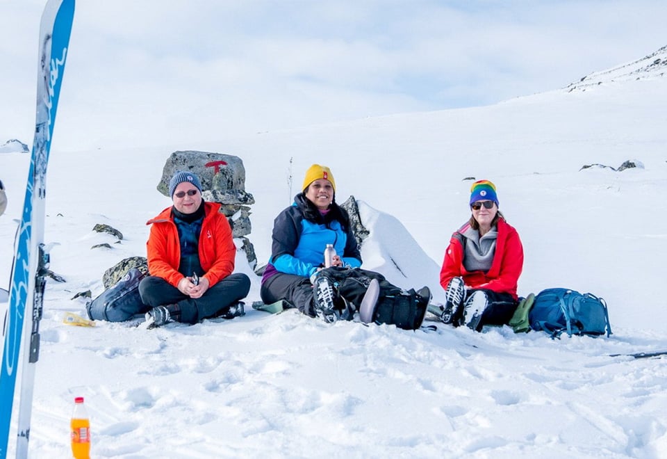 En gruppe skiløpere som sitter på snøen