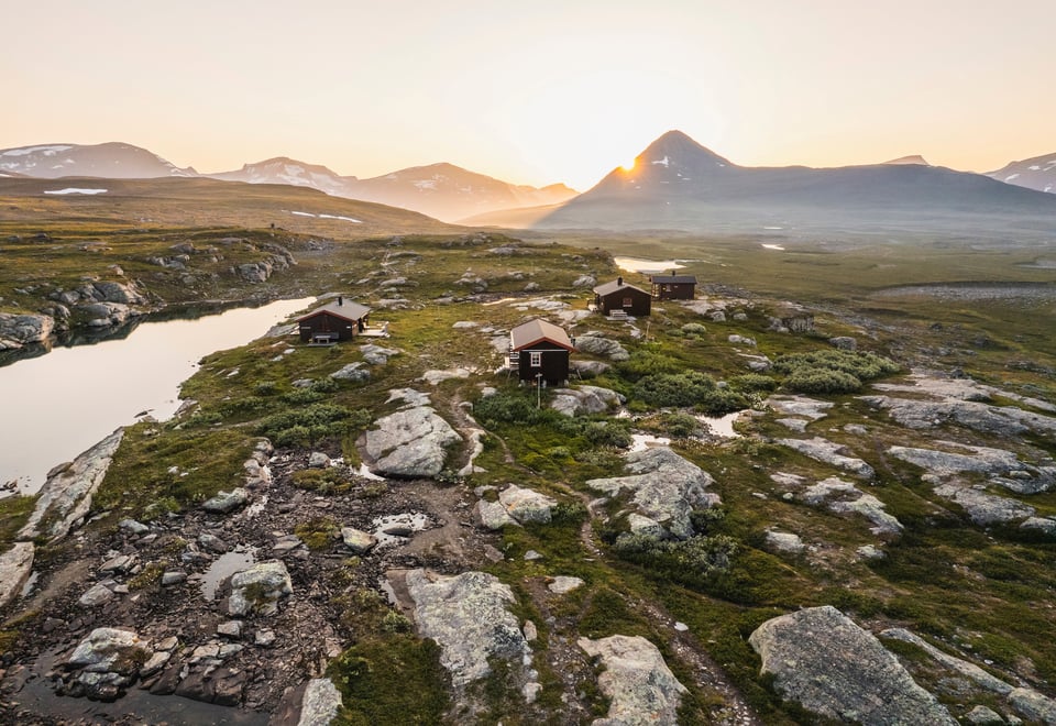 tre hytter i fjellandskap