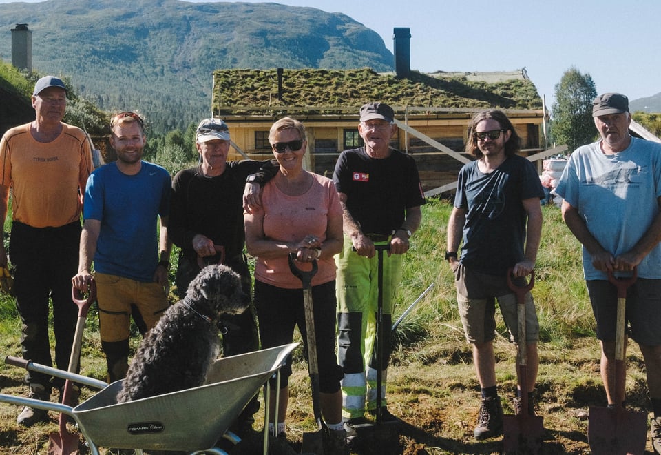 Personer som står ved en seter og smiler til kamera