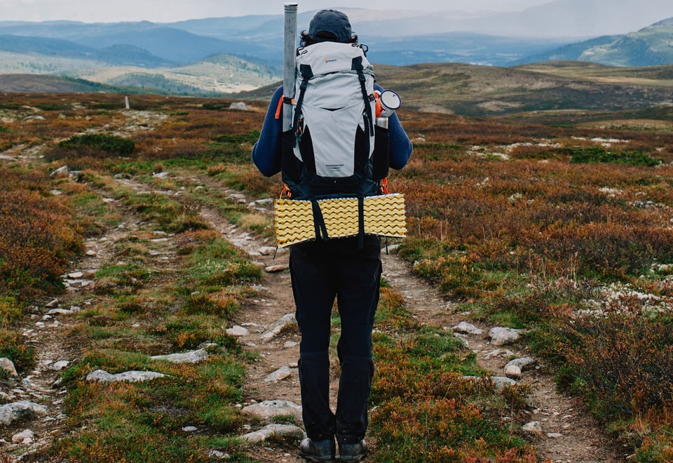 En mann med sekk som går tur i fjellet