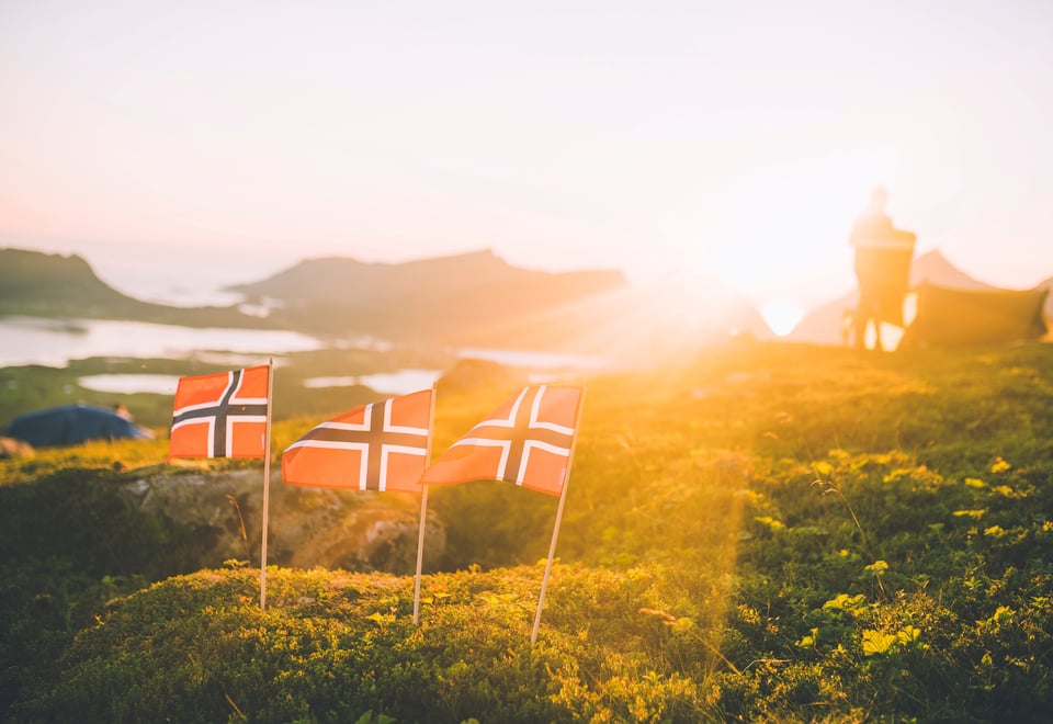 tre flagg i naturen i solnedgang