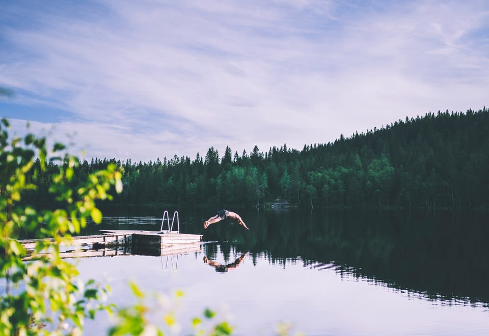 en person som stuper ned i en innsjø