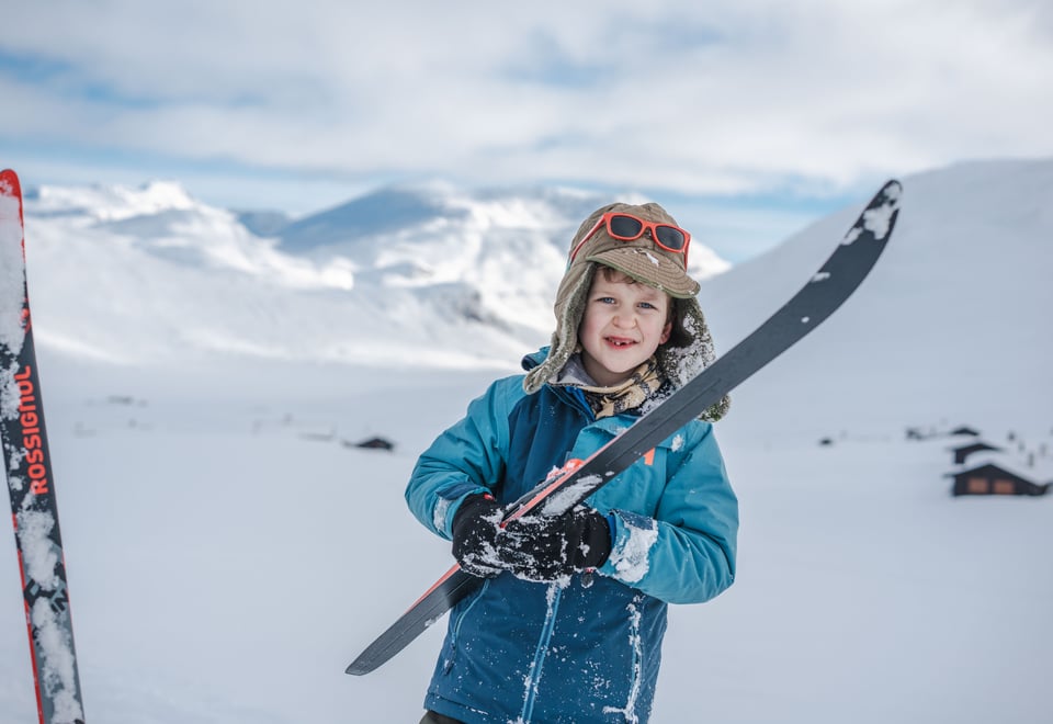 et barn i skidress i fjellandskap