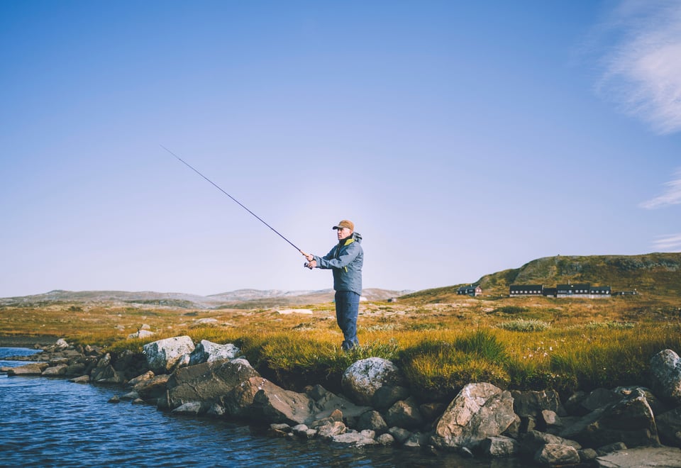 Reportasjetur over Hardangervidda i forbindele med jubileumsbok. Turgåer fisker ved vannet nedenfor Litlos turisthytte.
