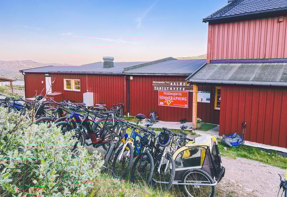 Rød hytte med mange sykler i forgrunn