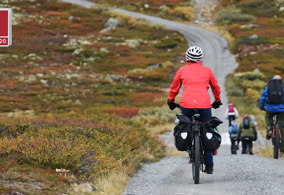 Mennesker som sykler på en grusvei