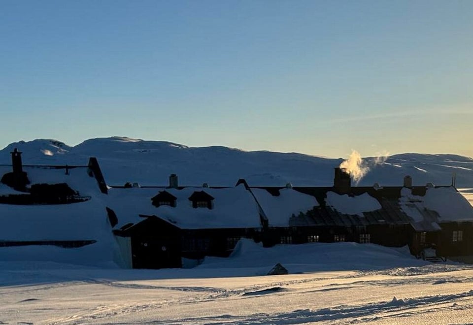 Vi ser hytta Sandhaug i vakkert vinterlandskap, i strålende sol.