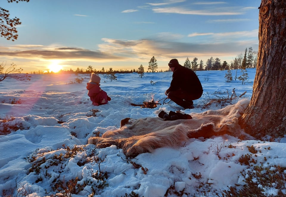Bålvarmen er god en vinterdag på skitur. Far og datter nyter varmen fra bålet. Soknedal, Midtre Gauldal.