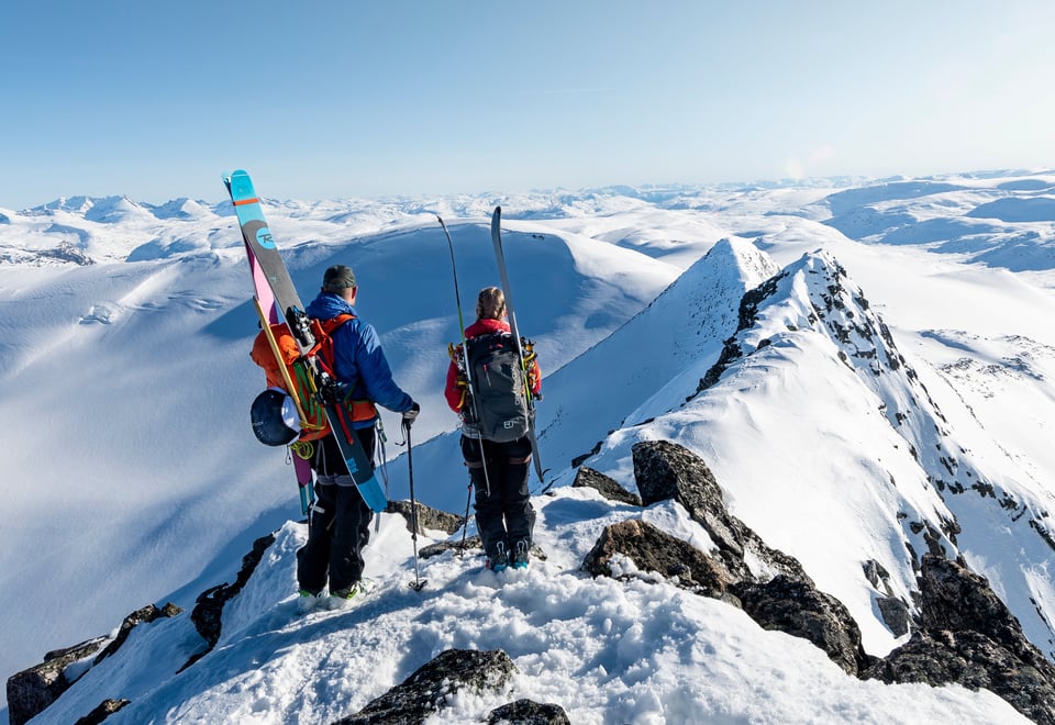 To personer som står på en fjelltopp