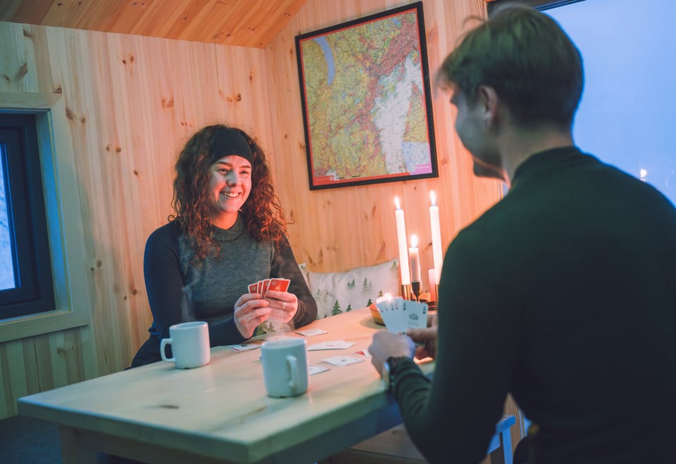 To personer spiller kort på dnt-hytte
