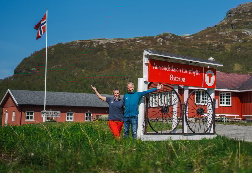 To personer som står ved et skil det står Aurlandsdalen Turisthytte