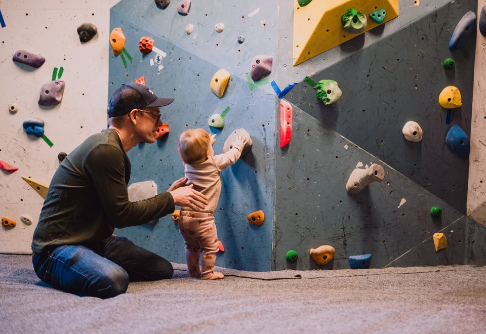 En mann og en baby som ser på en klatrevegg