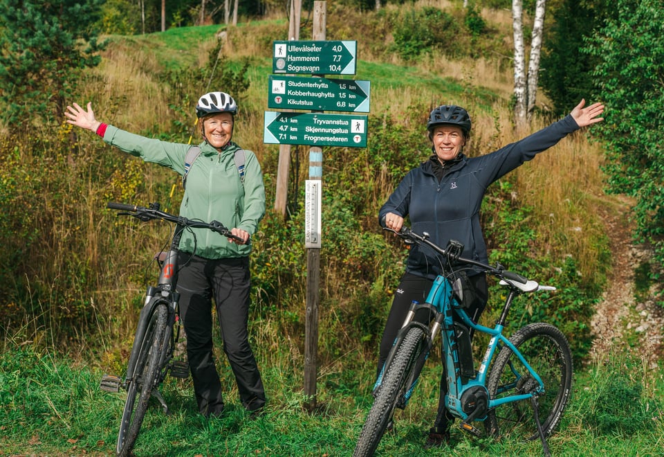 To personer på sykkel som jubler