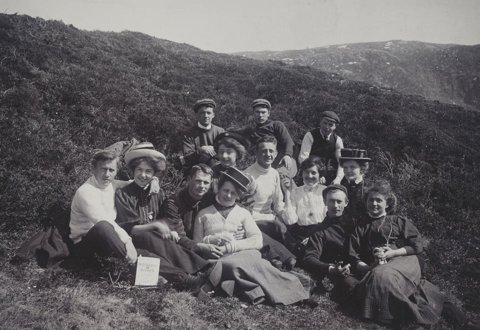 Historisk foto i svart-hvitt av pent kledd vennegjeng på tur i Byfjellene i 1908.