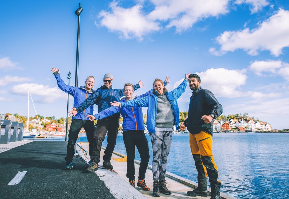 dem mennesker på en brygge i sola som tar armene i været