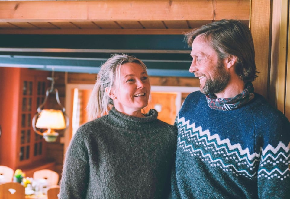 To personer smiler til hverandre inne på en hytte
