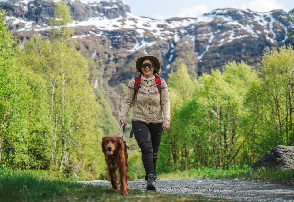 Dame som går med hund i Aurlandsdalen