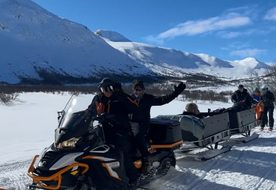 Personer som sitter på en snøskuter 