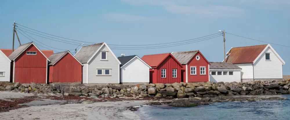 Flere hus tett inntil hverandre langs en brygge