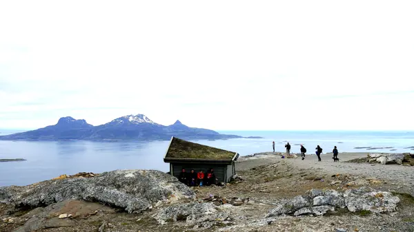 Gapahuk, litt folk og utsikt utover havet mot ei øy