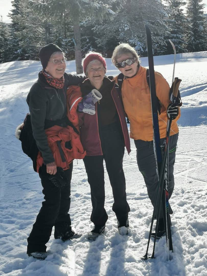 Tre glade damer på skitur