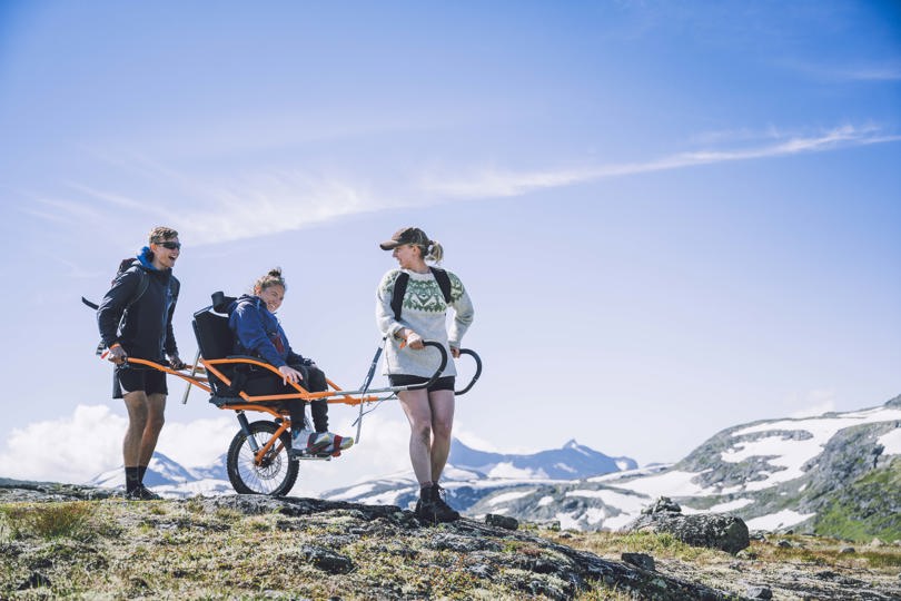 Tre ute på tur med en i rullestol