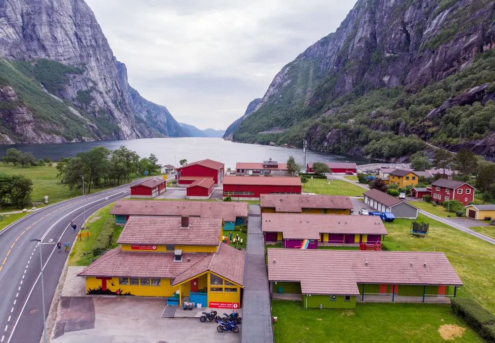 Oversiktbilde av hytteanlegget og de mange fargerike bygningene. Fjorden vises i bakgrunnen.