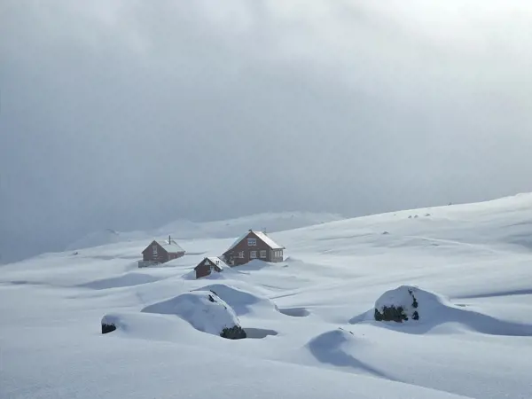 To hytter i snødekt vinterlandskap.