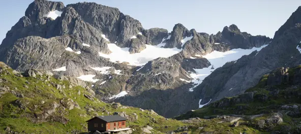 Hytte mellom høye fjell 