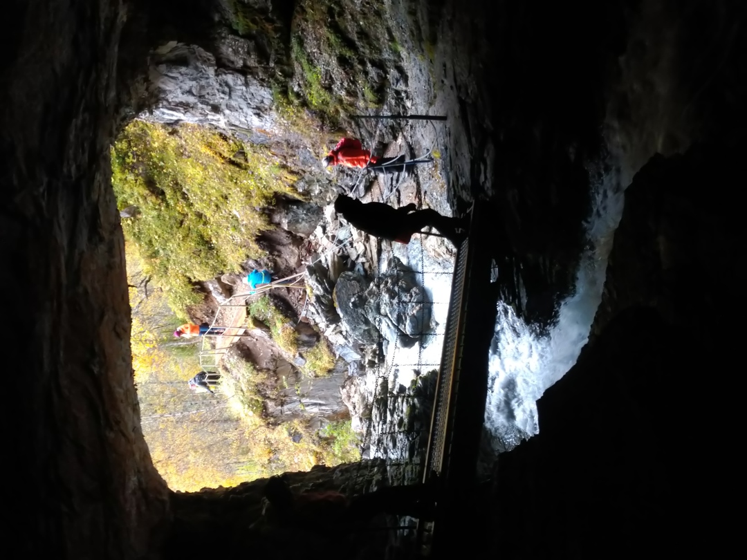 Turgåere som går inn en åpen grotte