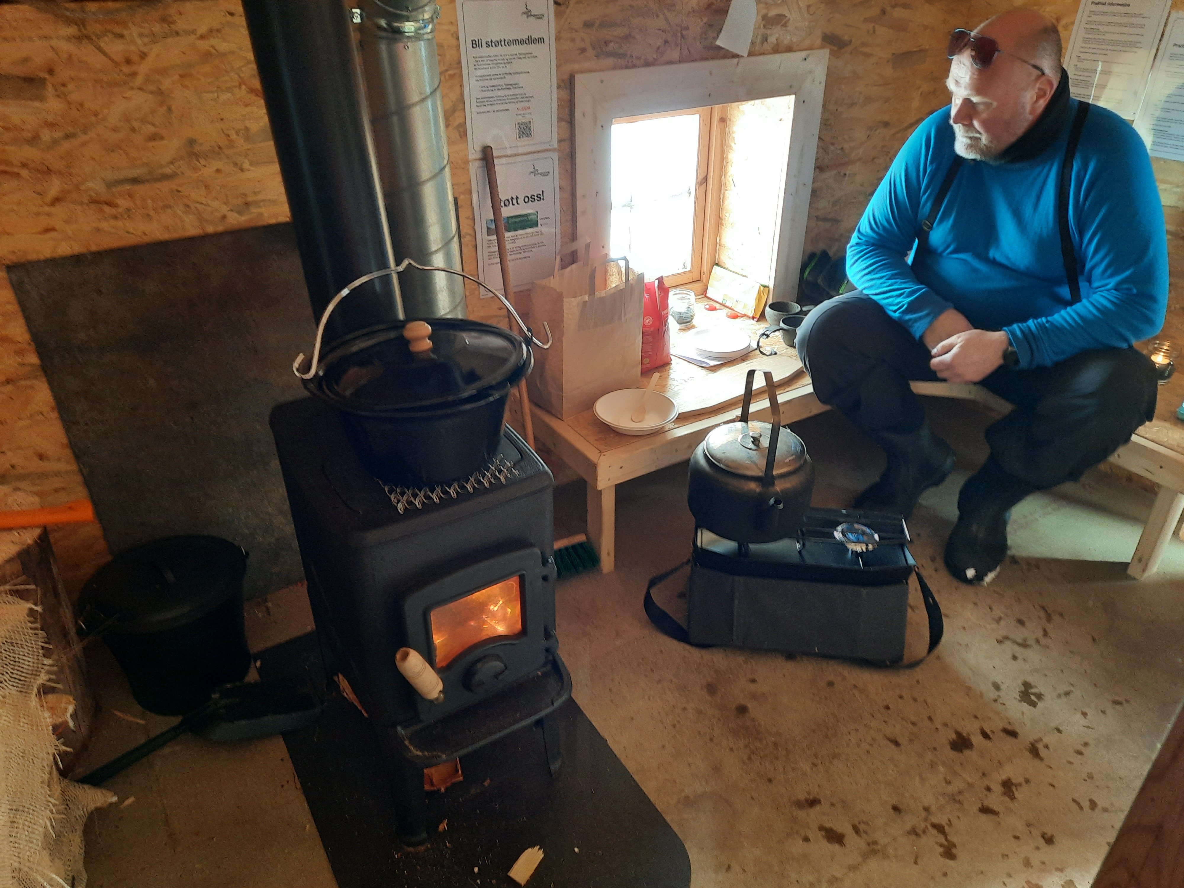 Mann koker kaffe p&aring; primus. Gryte p&aring; ovnen