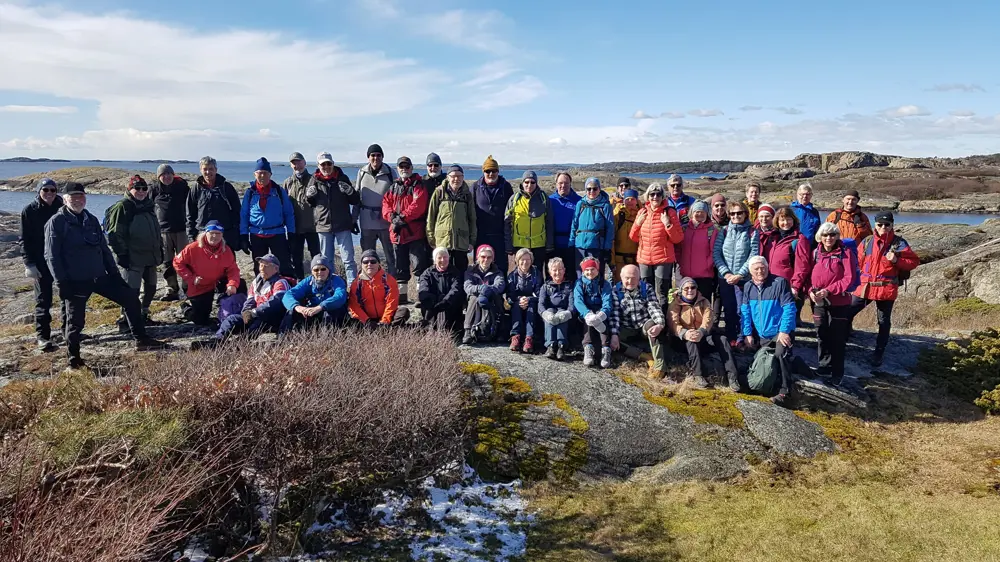 Mennesker står på rekke på fjell