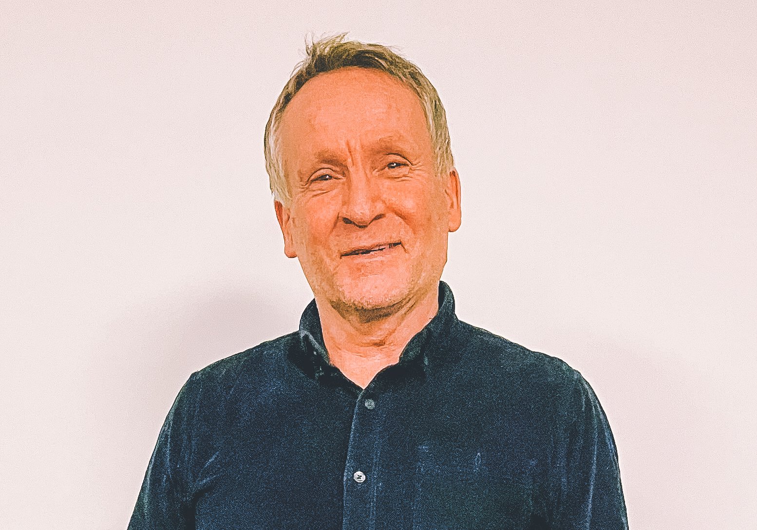 Portrett av en mann i halvfigurer foran en hvit vegg