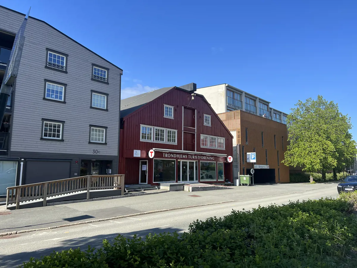 Fasadene på en rekke bygninger i en gate i Trondheim. Den røde bygningen i midten er Turisforeningens lokaler. 