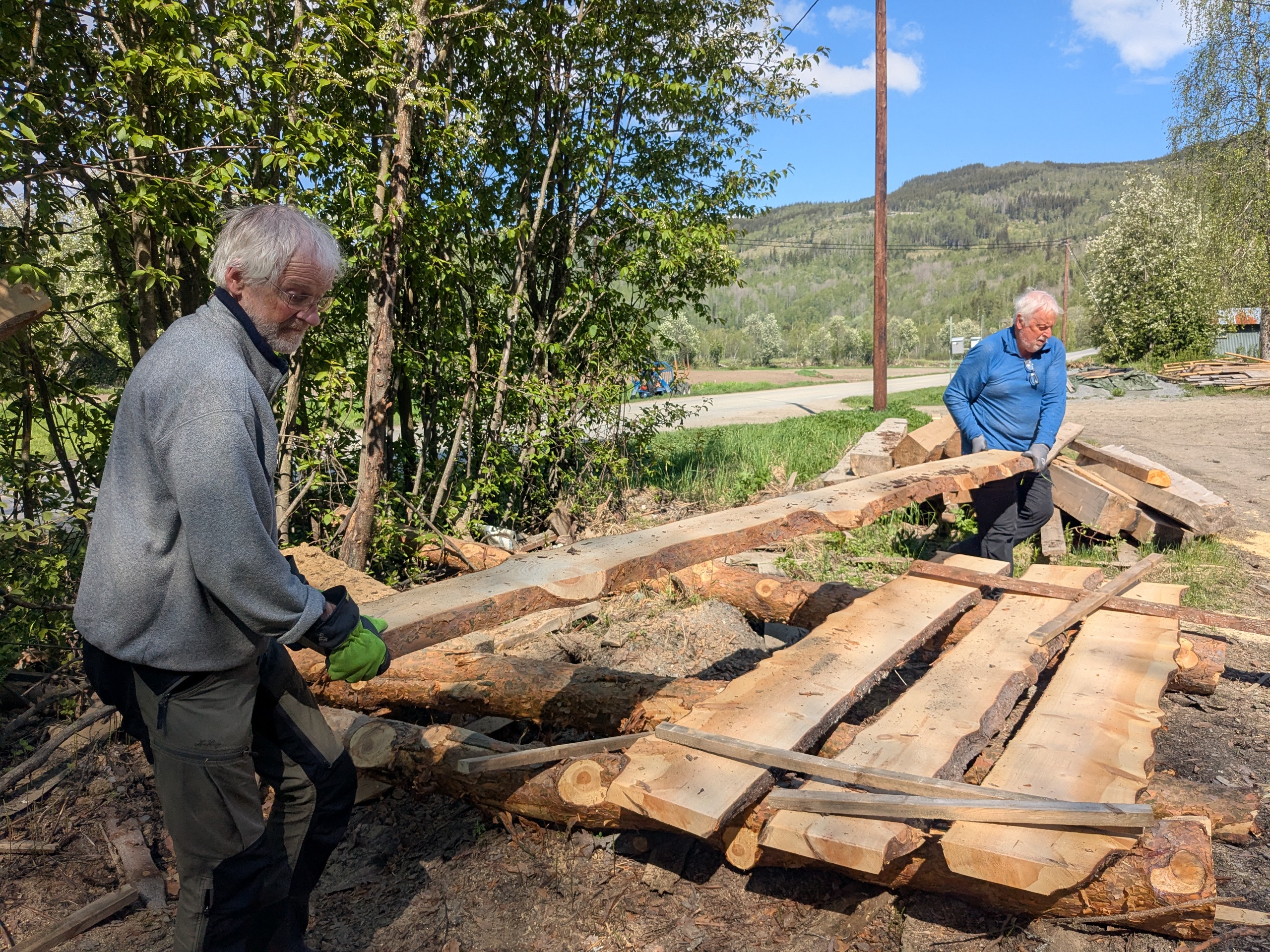 To personer jobber med kloppematerialer p&aring; henger