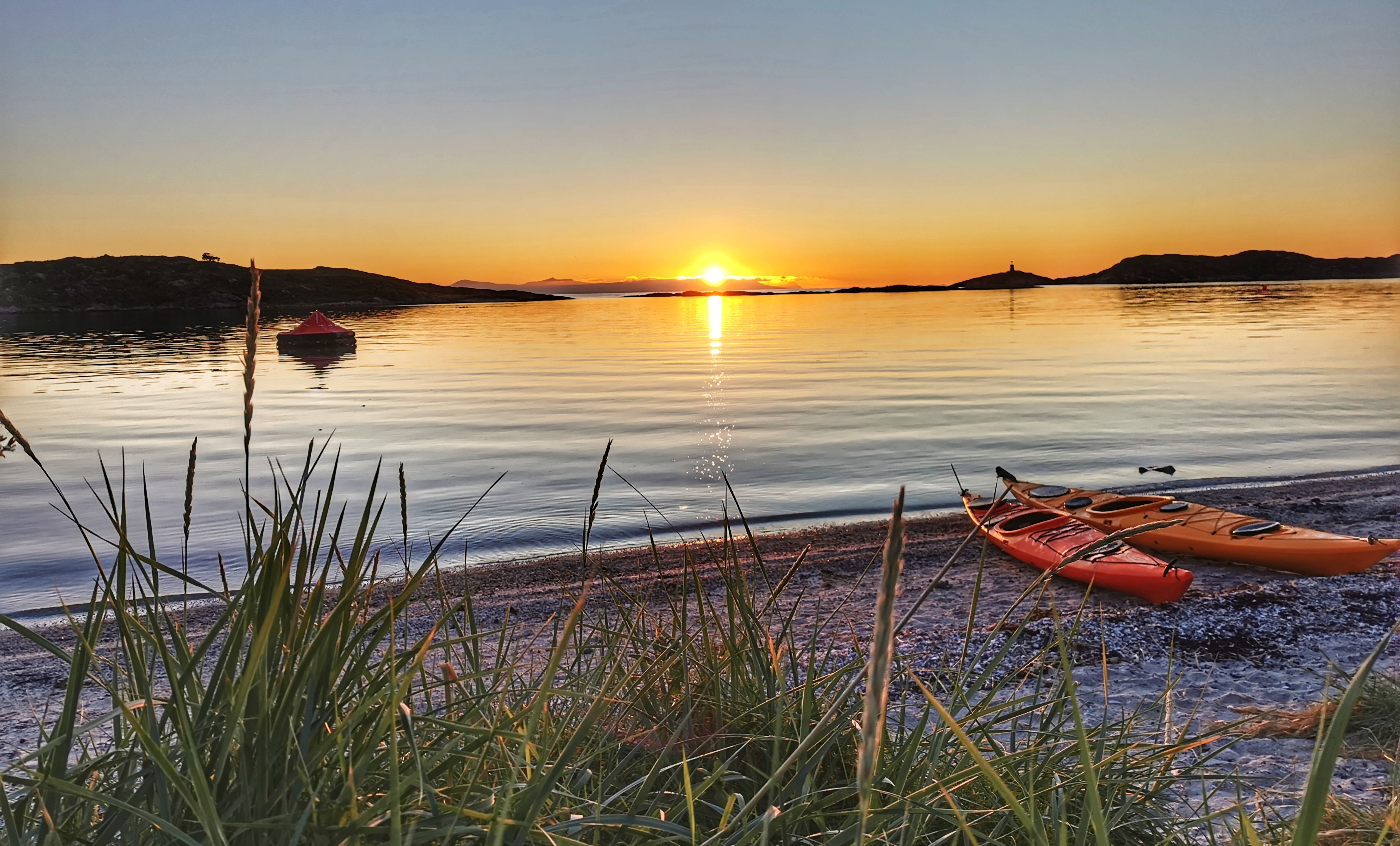 Midnattsol fra strand med kajakker ved &Oslash;yriket Camping 