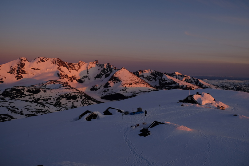 Solnedgang på en snødekket fjelltopp