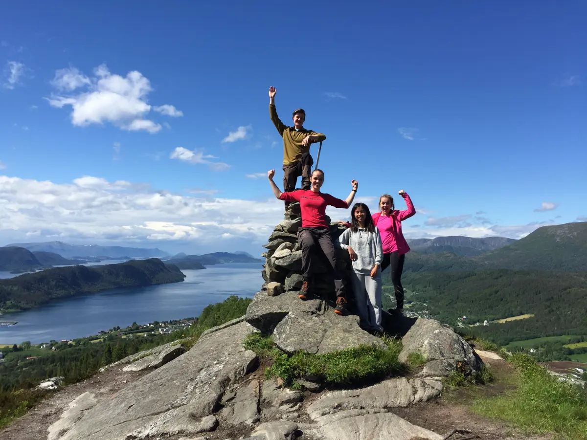 Turdeltakere på stein på fjelltopp