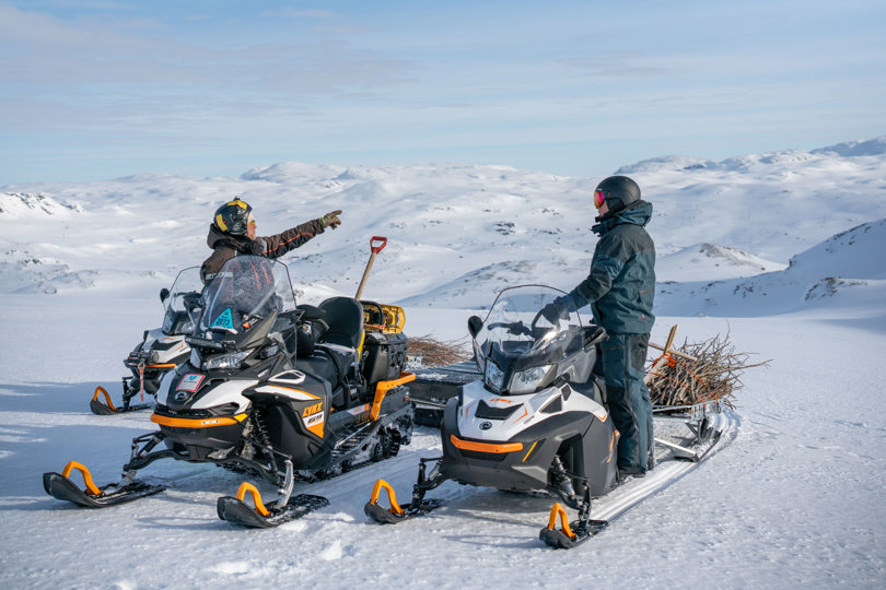 To personer på snøscooter