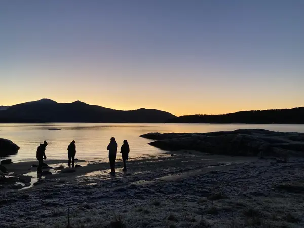 Fire personer og solnedgang på ei strand