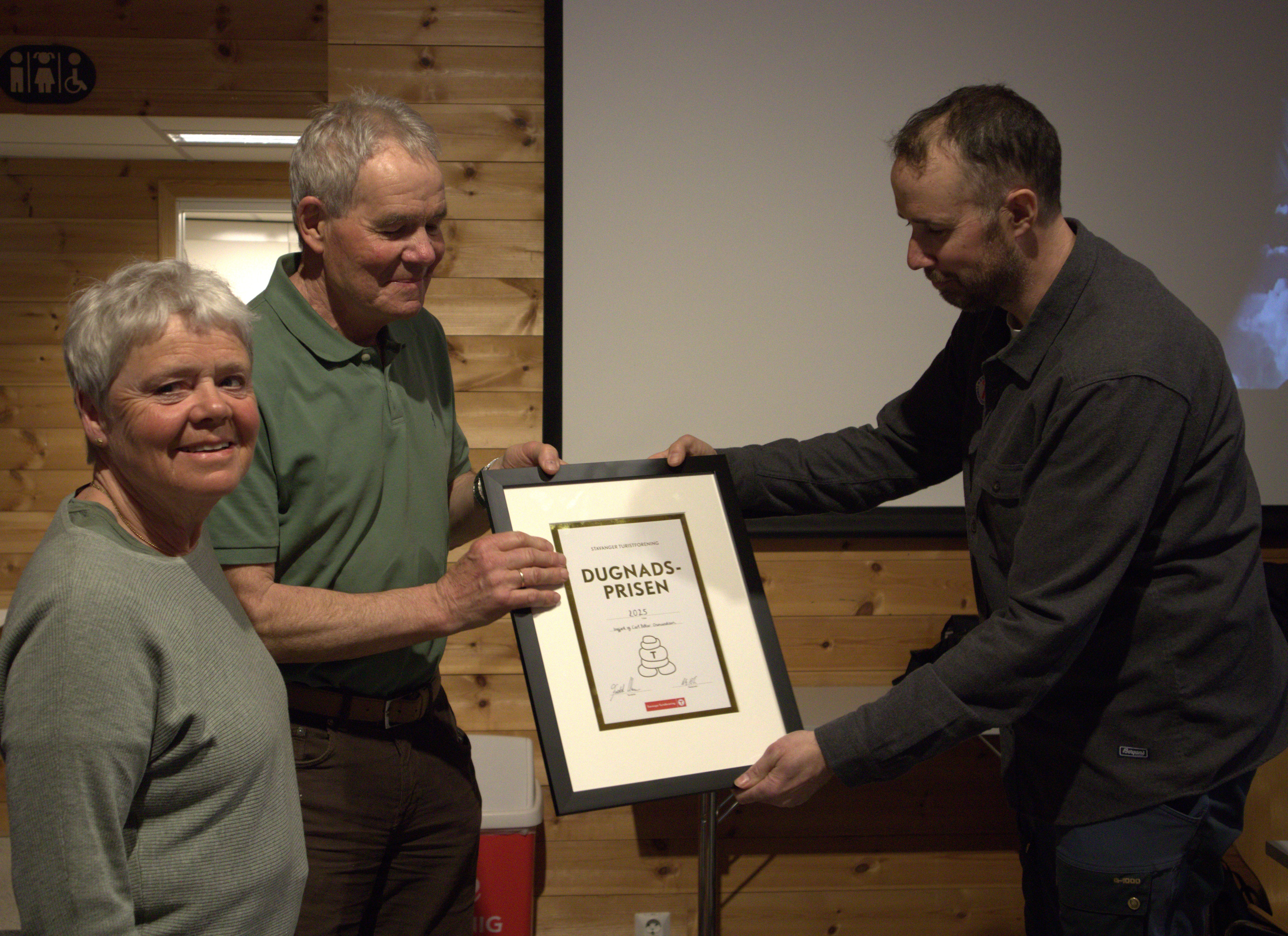 mann og dame f&aring;r diplom fra mann inne i et hus