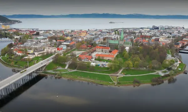 Et dronebilde av halvøya som Trondheim sentrum ligger på, sett ovenfra, med Elgeseter bru strekkende ut i nederste venstre hjørne, og fjorden synlig bak halvøya.