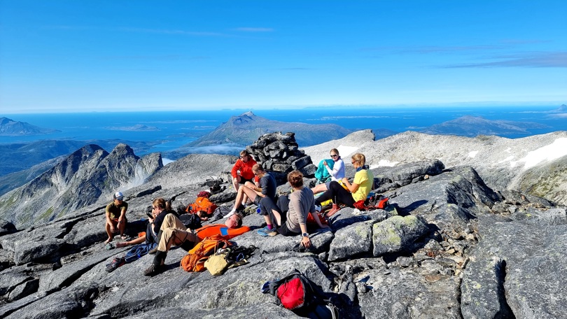 En gjeng på fellestur på toppen av Memaurtinden i Gildeskål