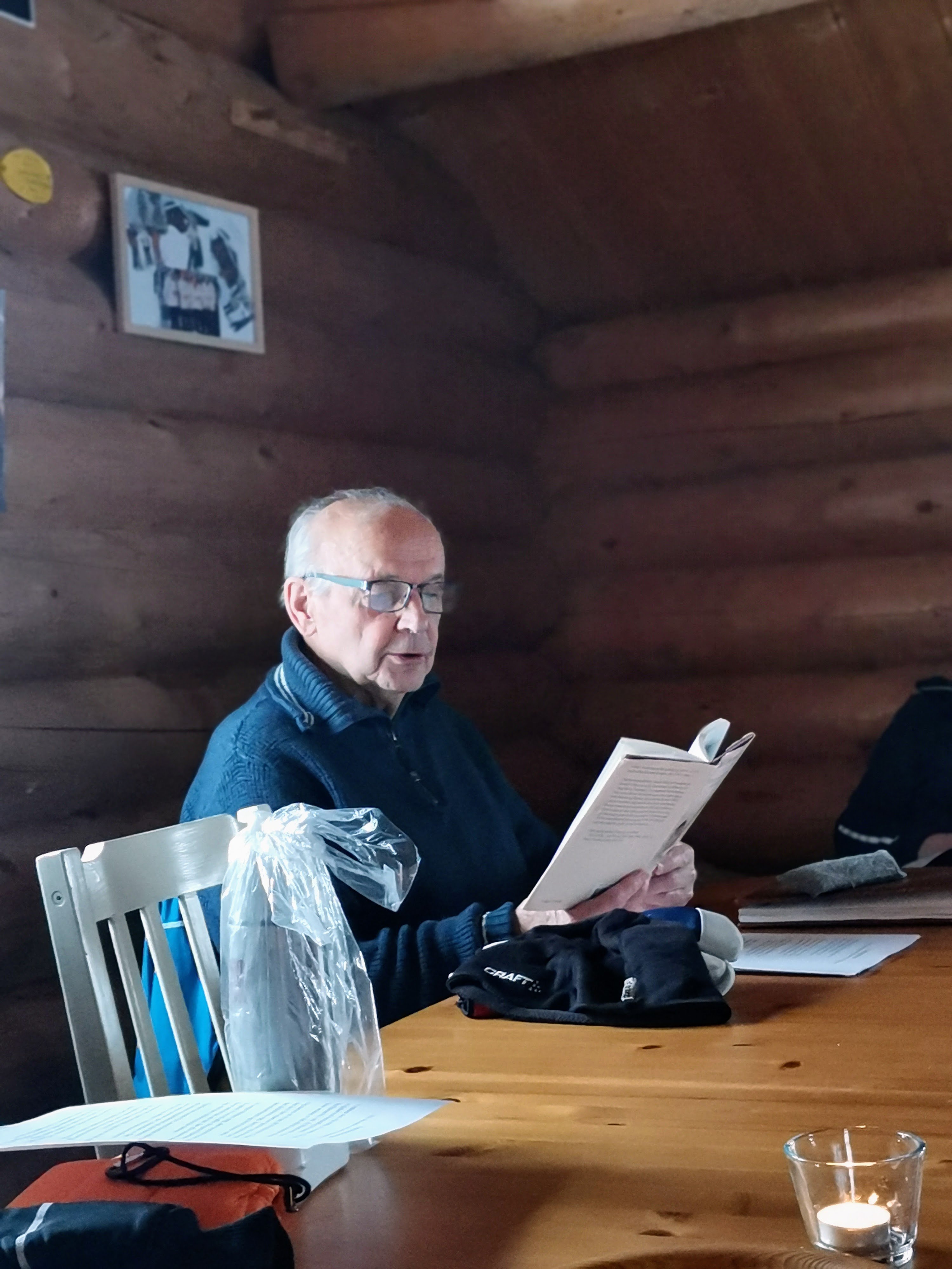 Mann leser h&oslash;yt inne i koia